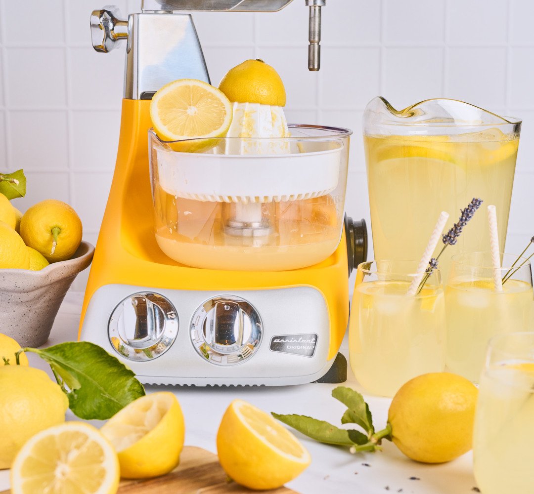 Ankarsrum sitruspuristimella varustettuna keittiön työtasolla. Kannuja täynnä vastapuristettua limonadia.