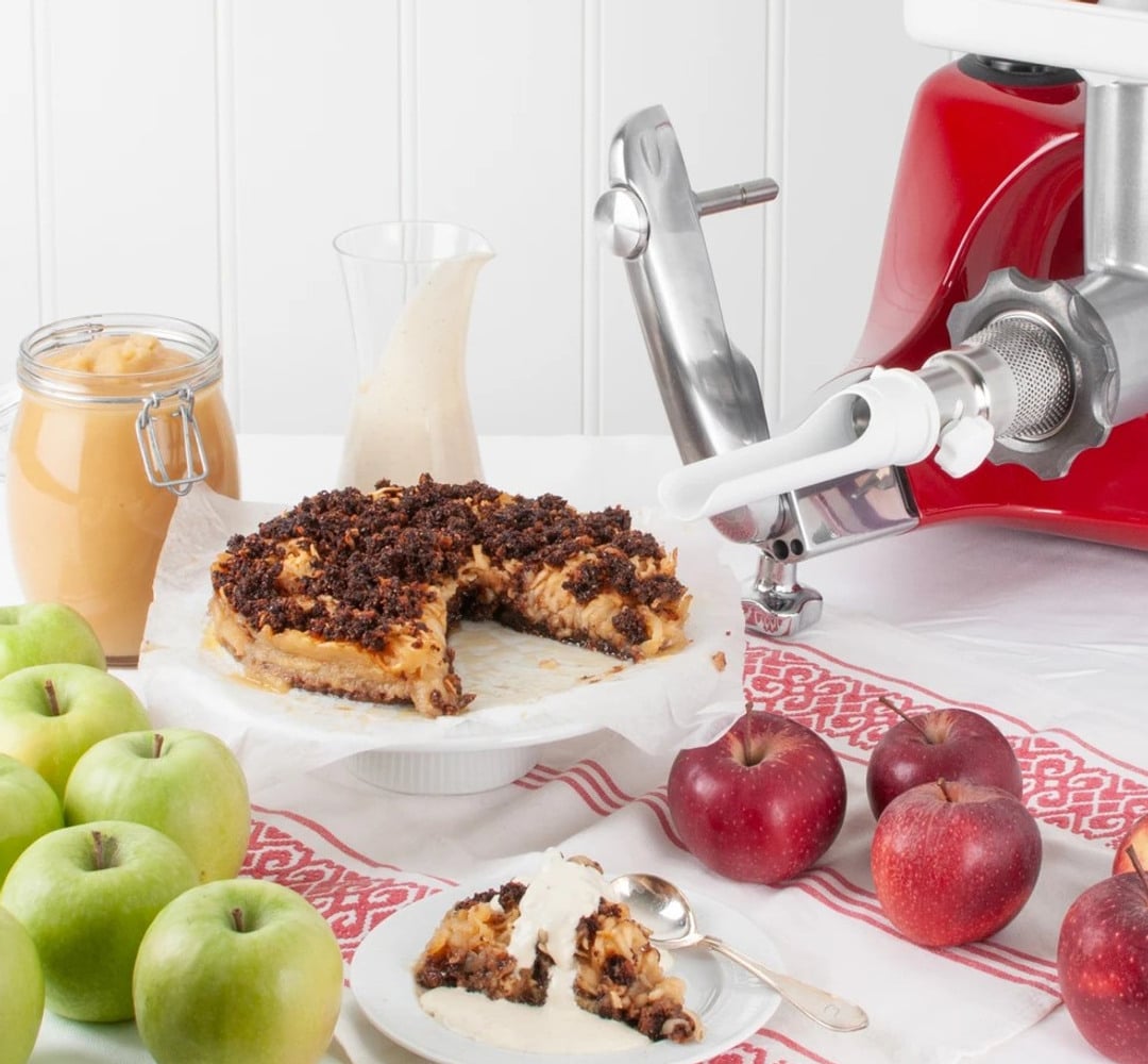 A table topped with a plate of apple cake and apples.