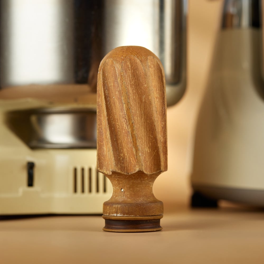 A close up of a wooden dough roller on a table.