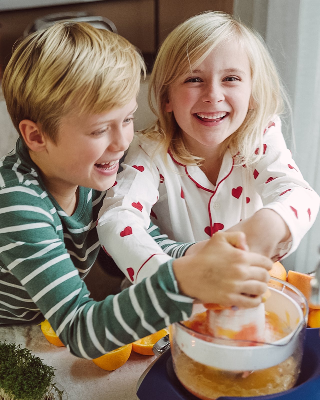 A boy and a girl doing orange juice together.