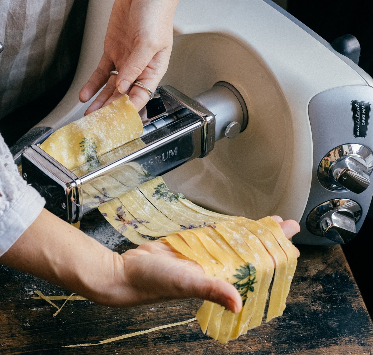 En person gör fettuccinepasta med pastatillbehöret på en Ankarsrum Assistent.