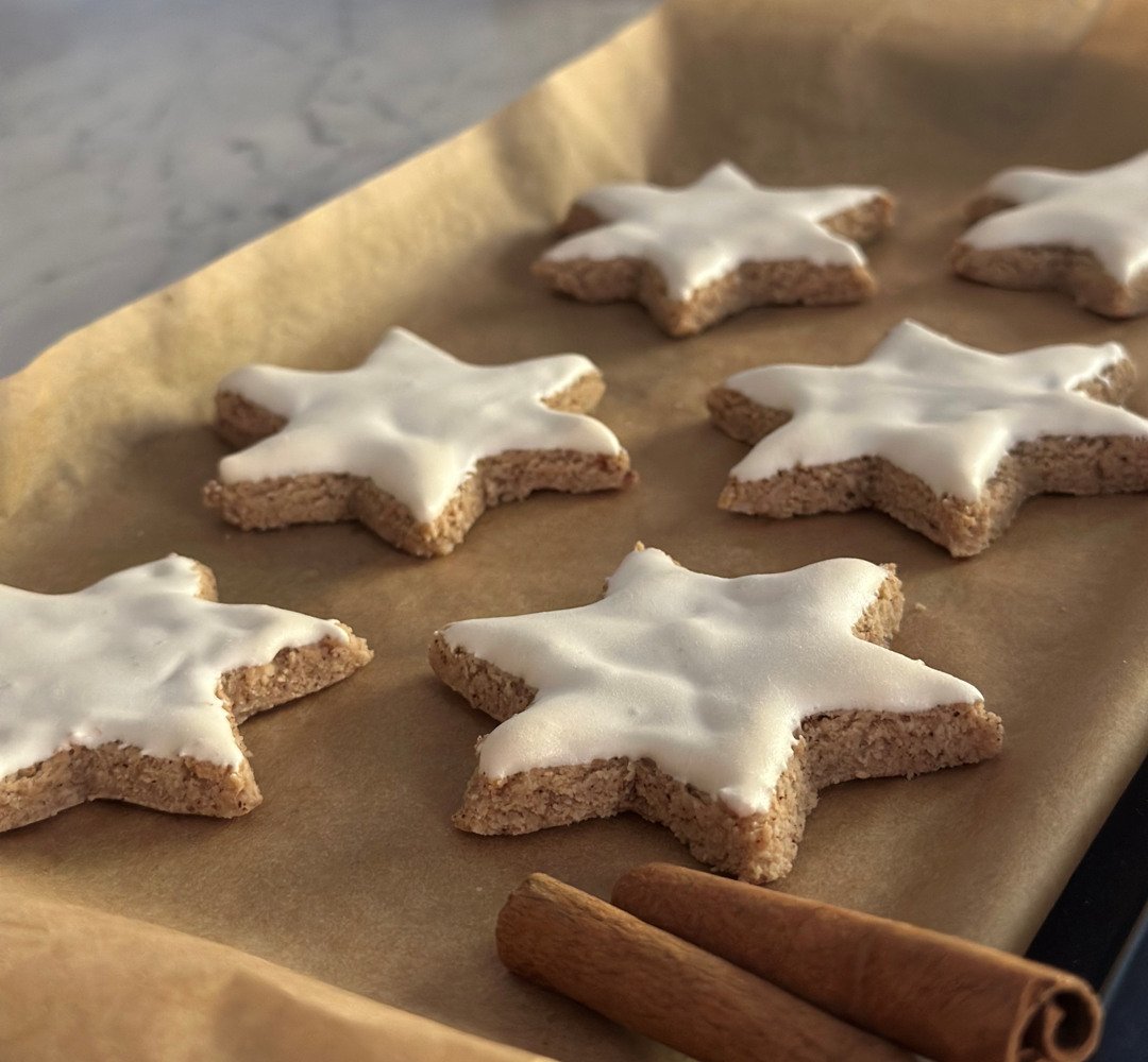 En bricka med kakor med glasyr och kanelstänger.
