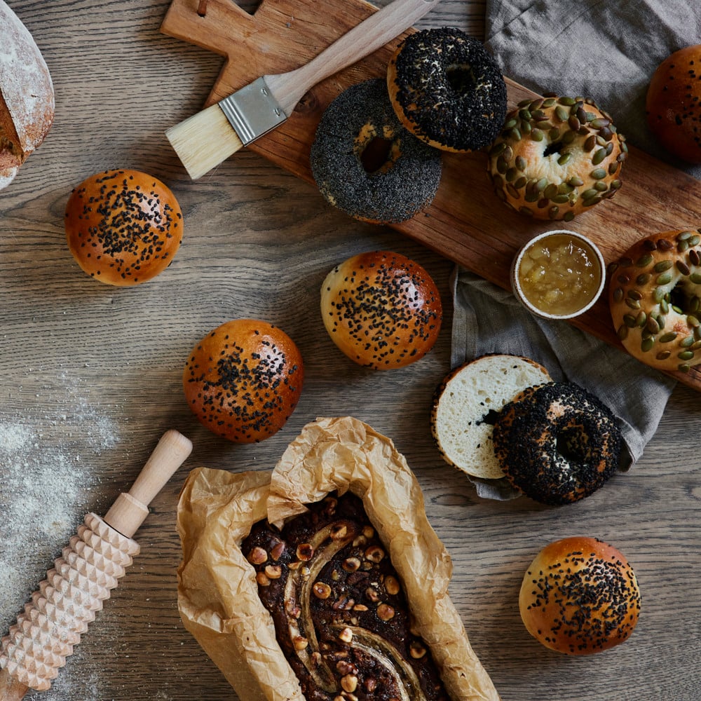 A table topped with lots of different types of bread.