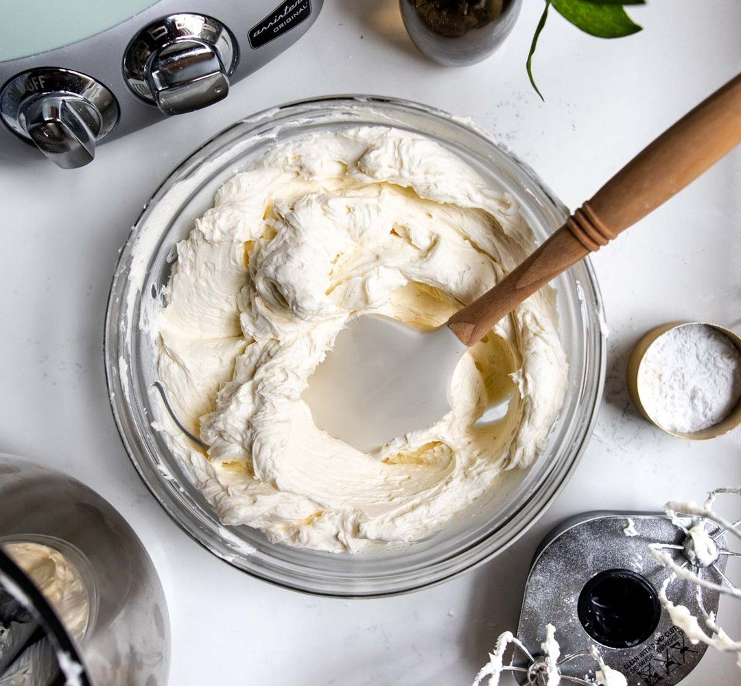 A bowl of whipped cream with a wooden spoon.