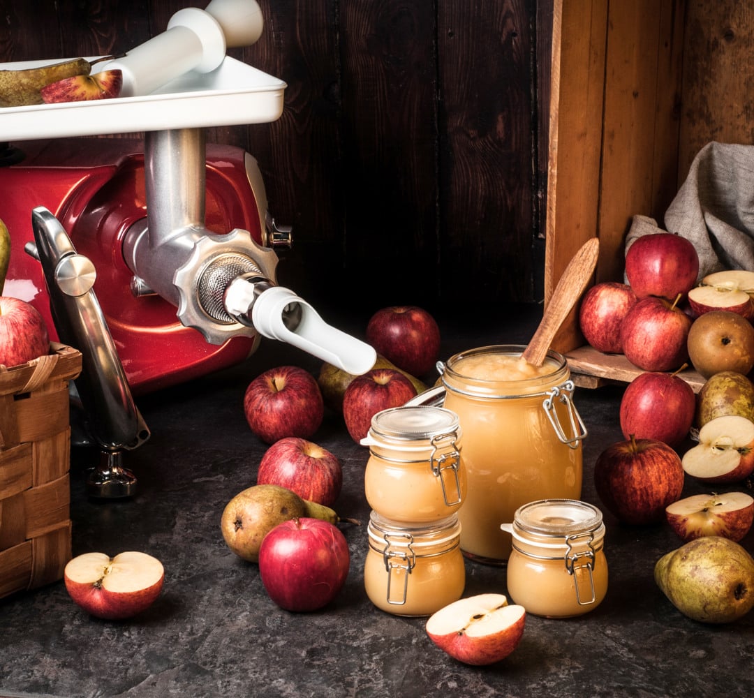 A table topped with apples and jars filled with pear and apple puree