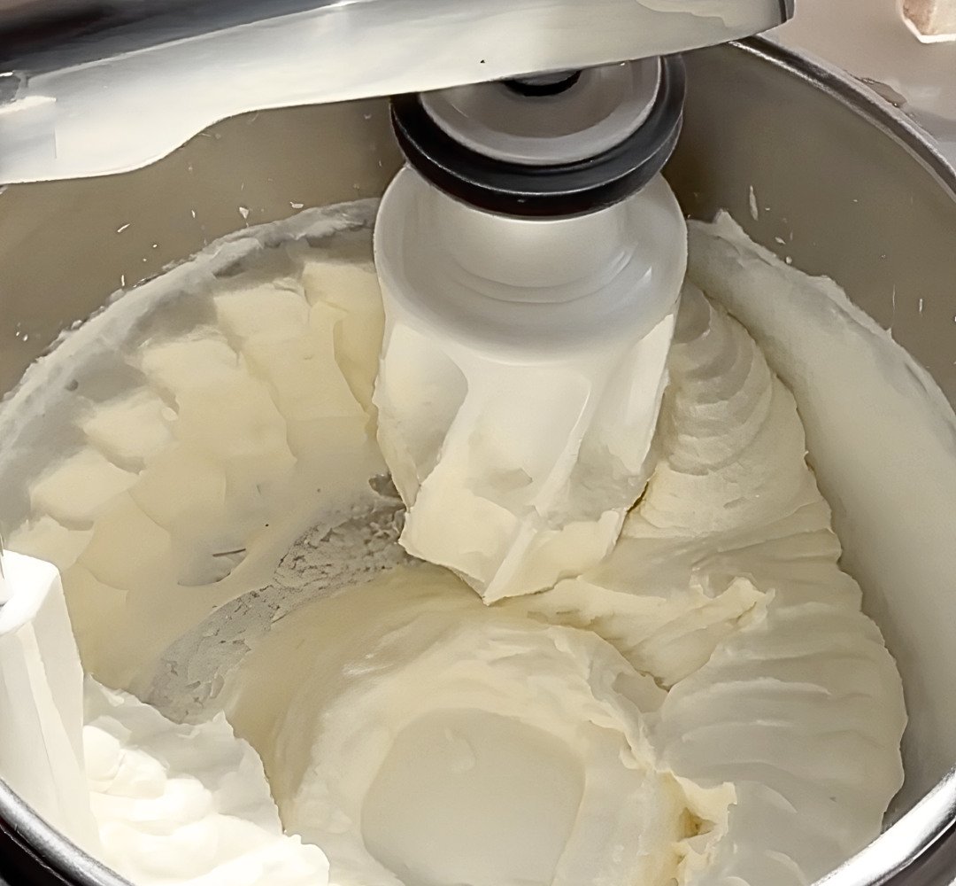 A mixer filled with whipped cream.