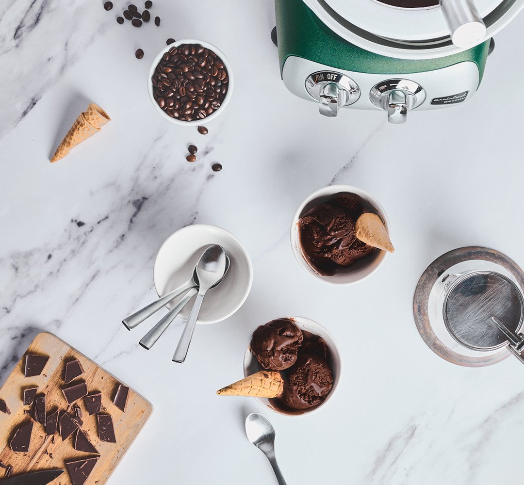 A bowl of chocolate and espresso ice cream, with spoons and spoons next to it.