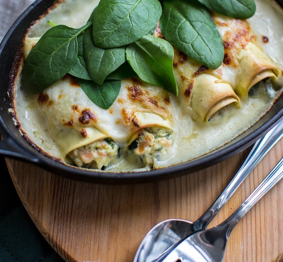 En stekpanna fylld med pastacannelloni och spenat.