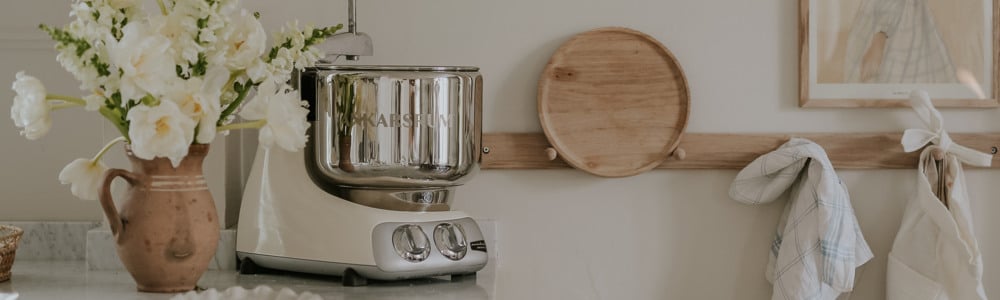 A kitchen counter with a blender and a vase of flowers.