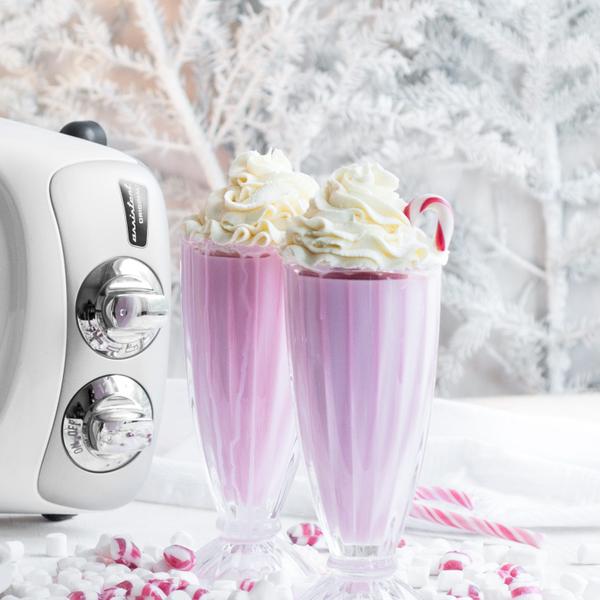 Two Christmas milkshakes with fluffy whipped cream and sugar candy canes