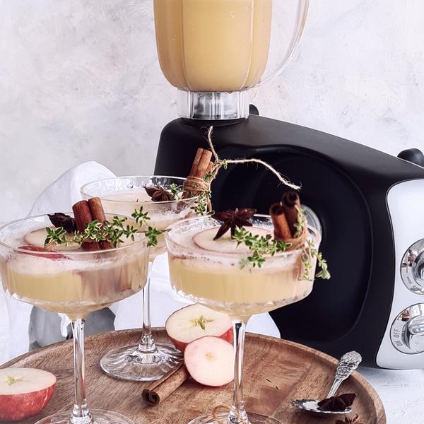 Two glasses on a tray filled with a Christmas drink with apples