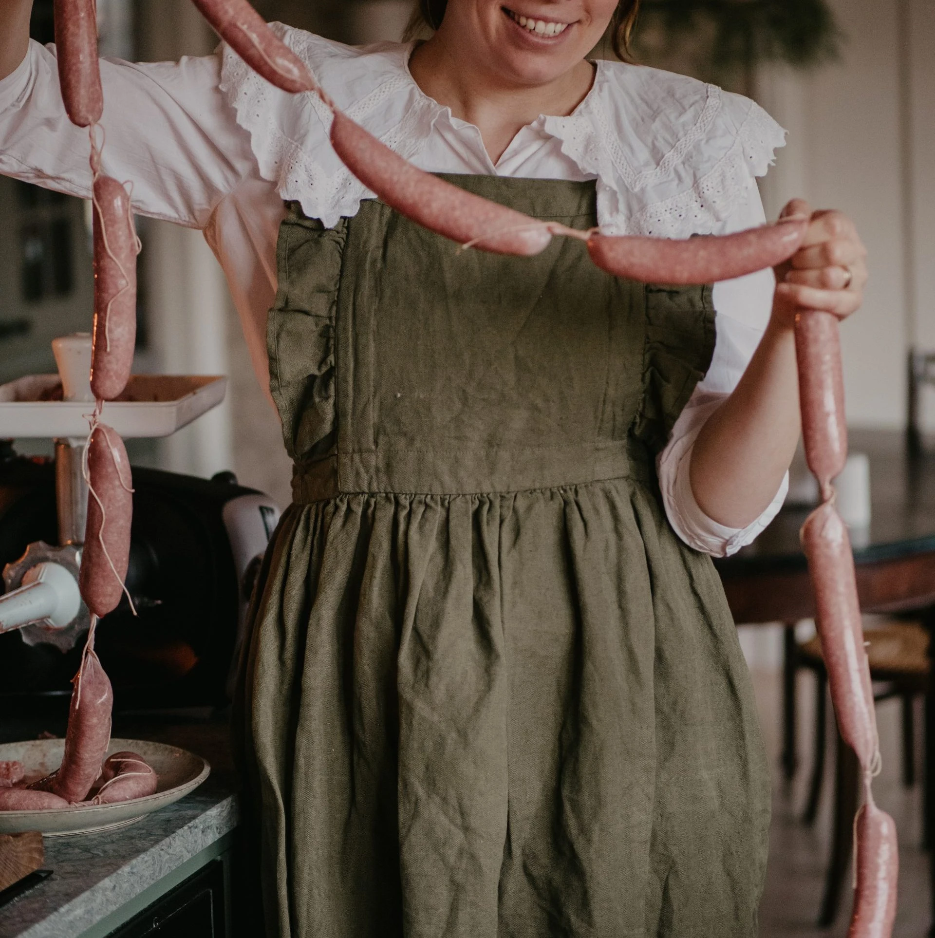 A woman that is holding a homemade festive Christmas sausage