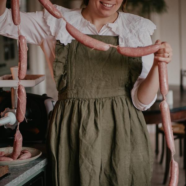 A woman that is holding a homemade festive Christmas sausage