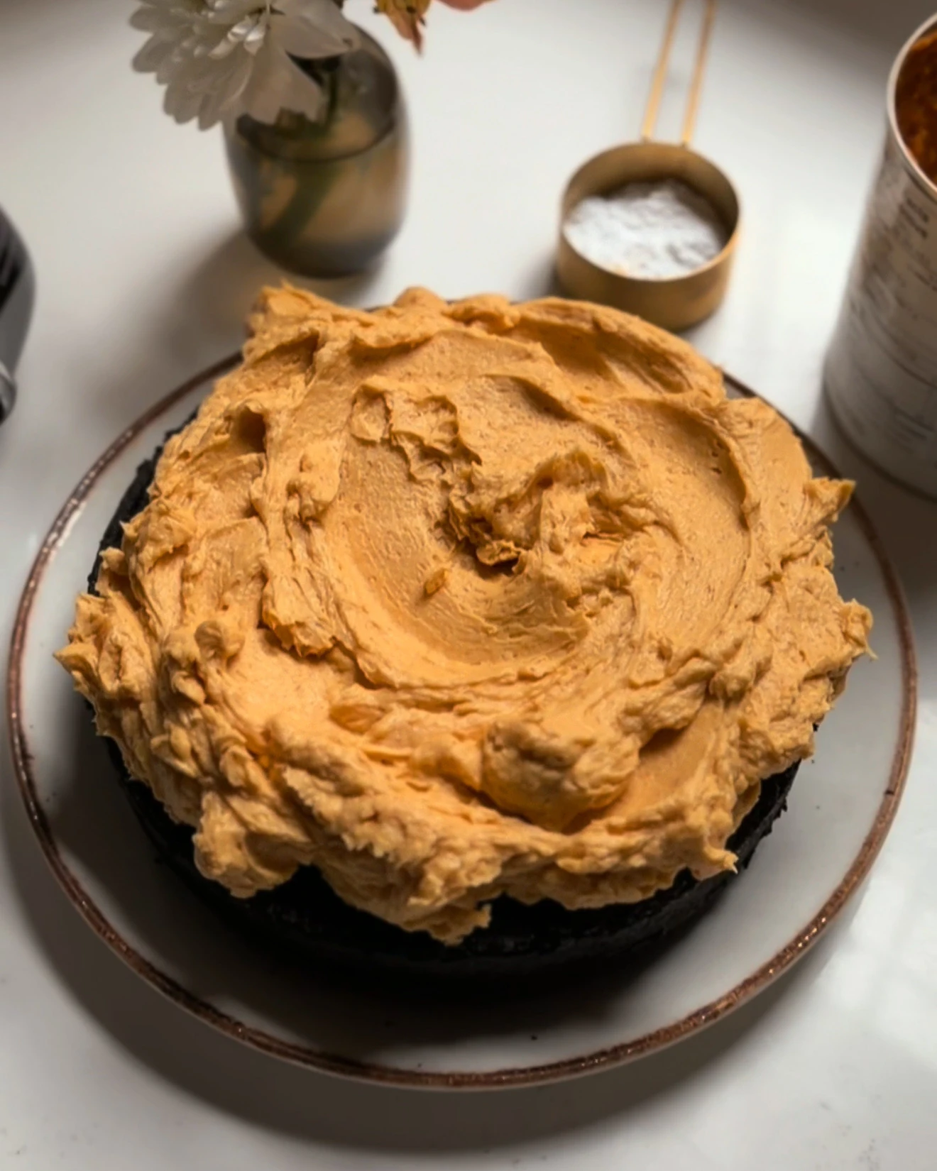Black Chocolate Cake with pumpkin buttercream on a white table