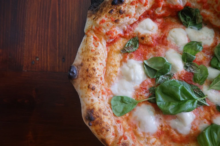 Freshly baked Neapolitan margherita pizza with mozzarella, tomato sauce, and basil leaves made with Ankarsrum stand mixer.