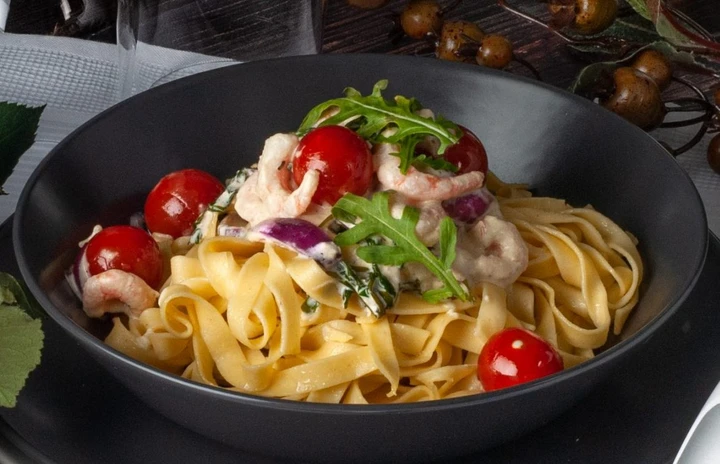 en bild på ett bord med rosor, pasta, köksmaskinen, och bestick.