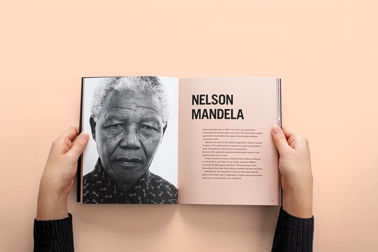 Book open to Nelson Mandela page with his black and white portrait photo and biographical text about his human rights legacy.