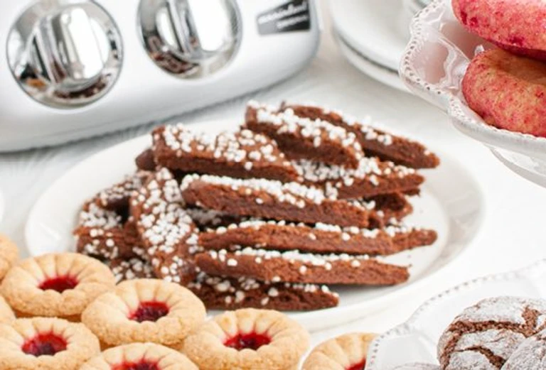 Assorted holiday cookies including chocolate sticks with pearl sugar and jam thumbprint cookies made with Ankarsrum stand mixer.