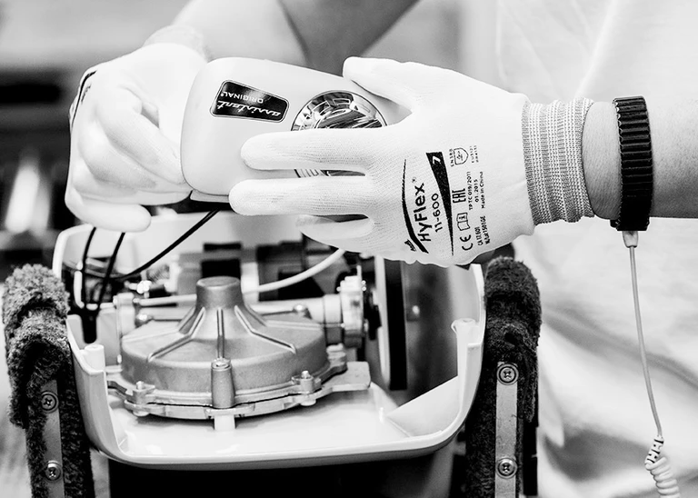 Technician wearing HyFlex 11-800 gloves assembling an Ankarsrum Original stand mixer motor component.