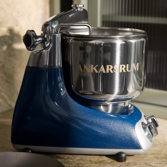 Close-up of the Ankarsrum Assistent Original in Ocean Blue on a marble countertop.