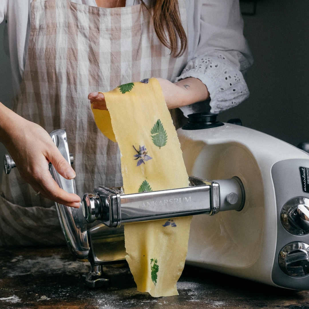Pastadeg med örter valsas genom Ankarsrums pastavalsar för att skapa dekorativa och tunna degark.
