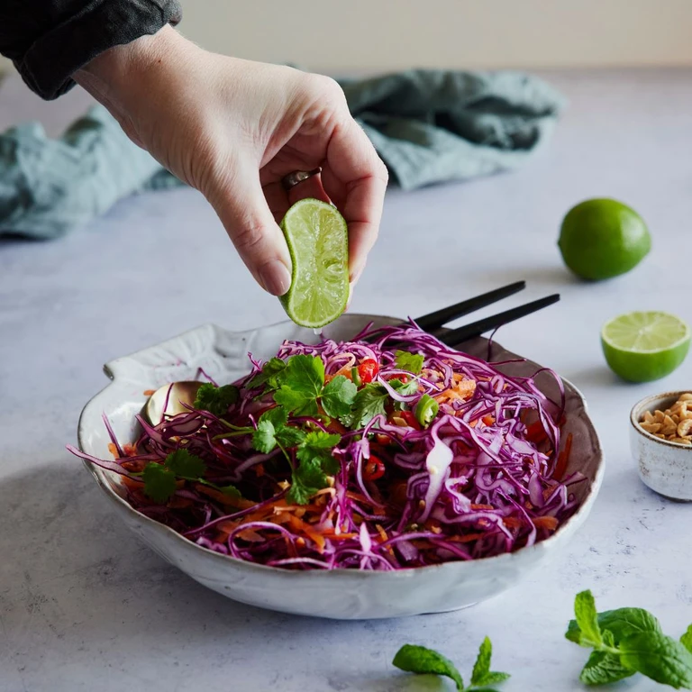 An Asian salad with cabbage, cattors, topped with coriander and peanuts