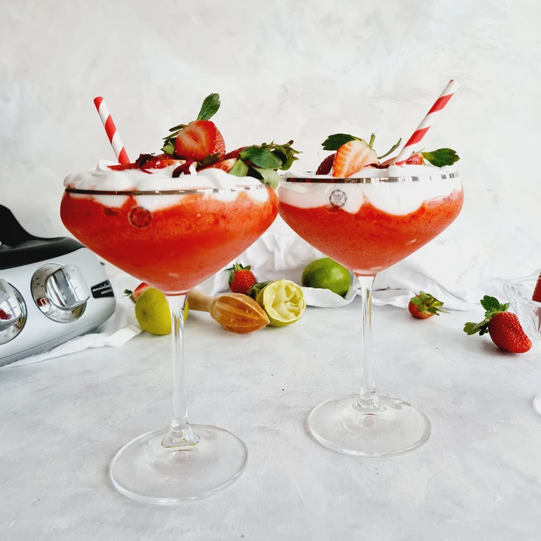 two red Strawberry drinks on a table
