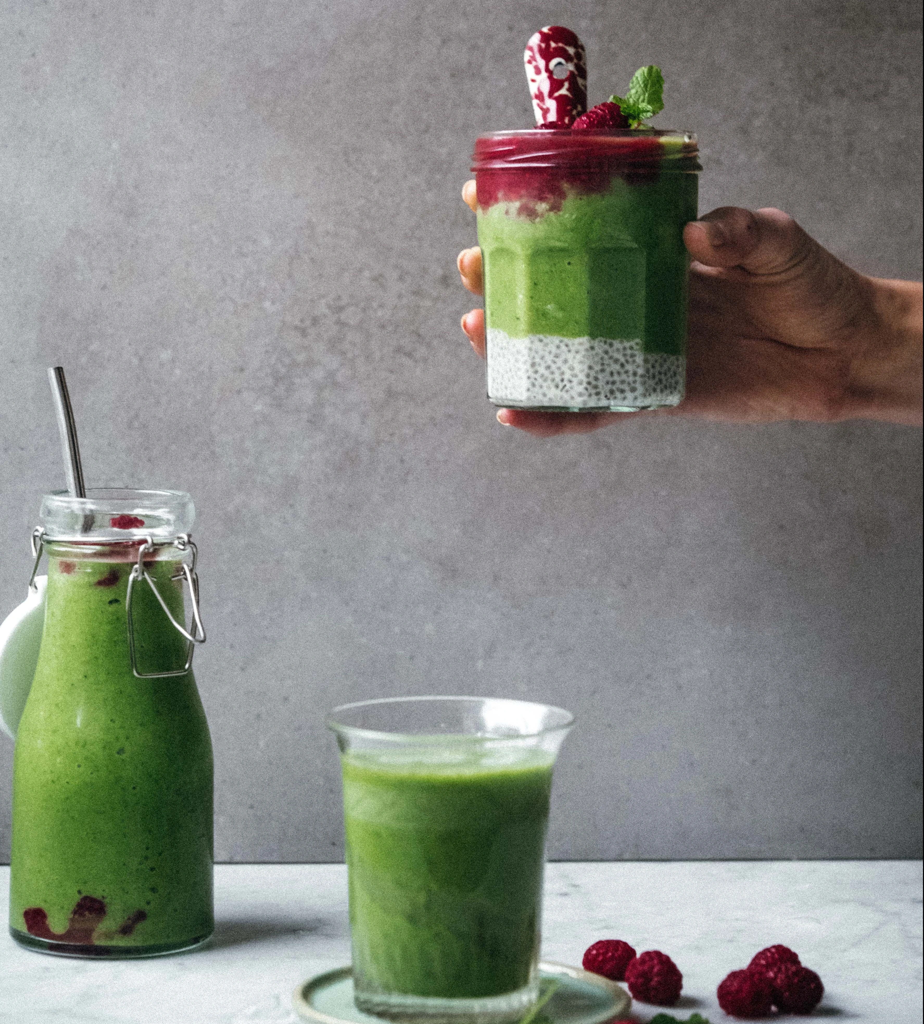 Green smoothie layered chia pudding jar with raspberries, mint, plus green smoothie bottle and glass, made with Ankarsrum mixer.