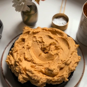 Black Chocolate Cake with pumpkin buttercream on a white table