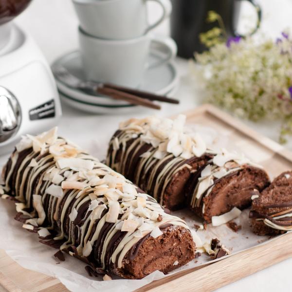 A chocolate roll cake with chocolate filling topped with two kinds of chocolate.