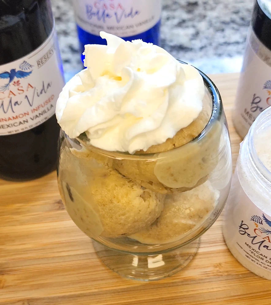 Bowl of Boozy Rum Raisin ice cream with whipped cream on top.
