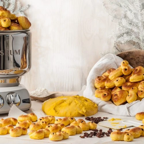 Fluffy saffron buns with raisins on top arranged on the table