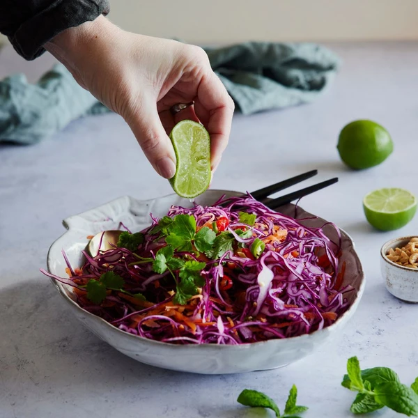 An Asian salad with cabbage, cattors, topped with coriander and peanuts