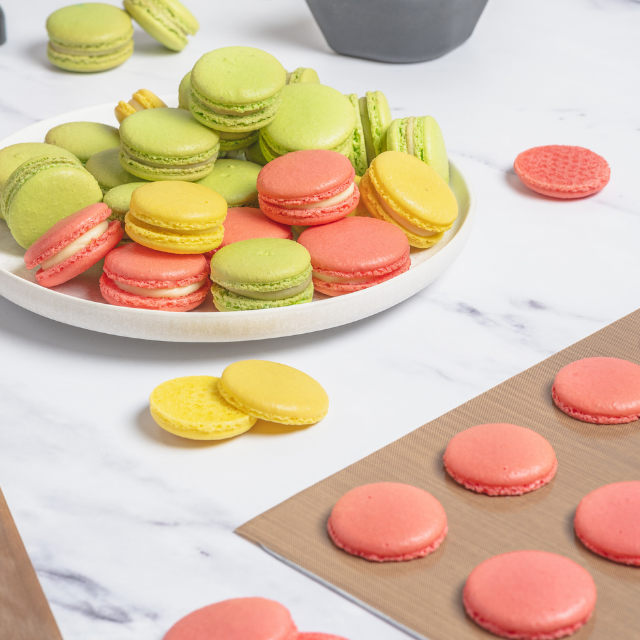 Färgglada macarons i gult, rosa och grönt.
