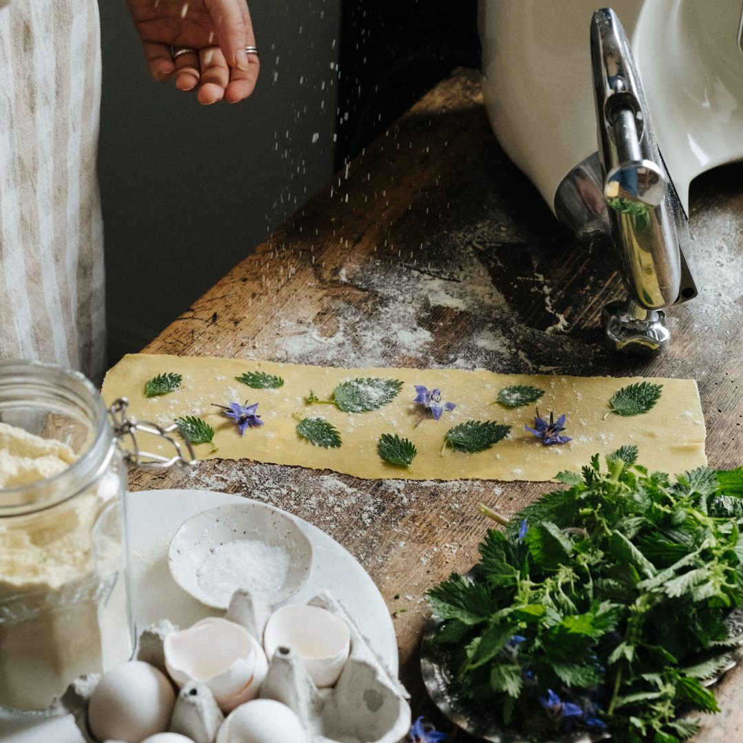 Hemgjord pasta fint dekorerad med รถrter och blommor.