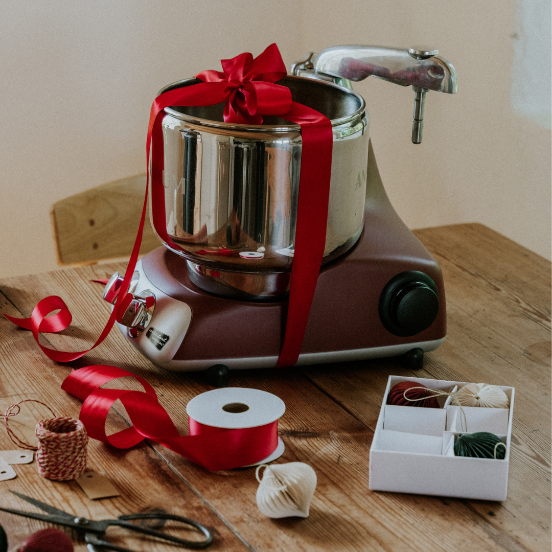 Ankarsrum kรถksmaskin inslagen som julklapp med rรถtt sidenband.