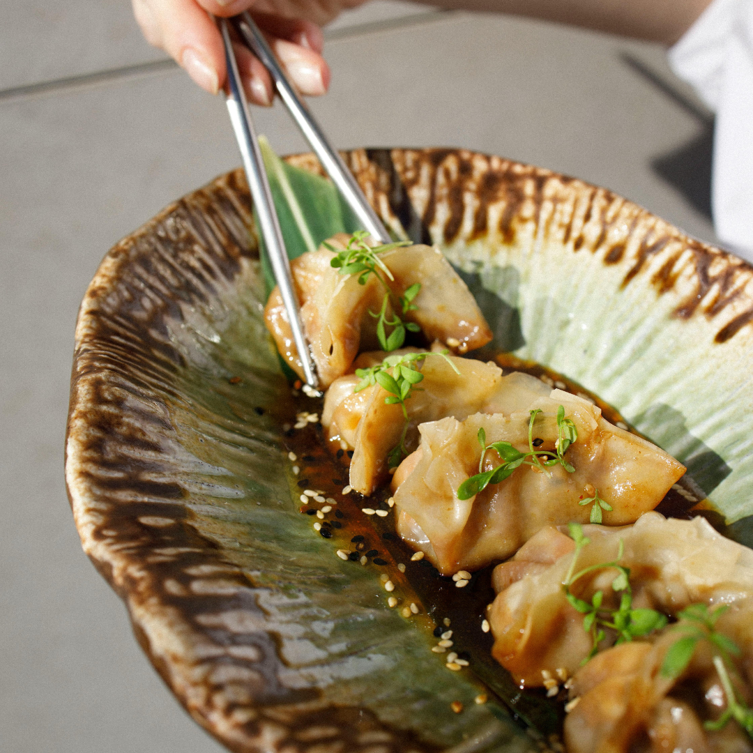 Närbild på nygjorda dumplings med soja- och sesamdressing, gjorda med tunn deg från Ankarsrums pastavalsar.