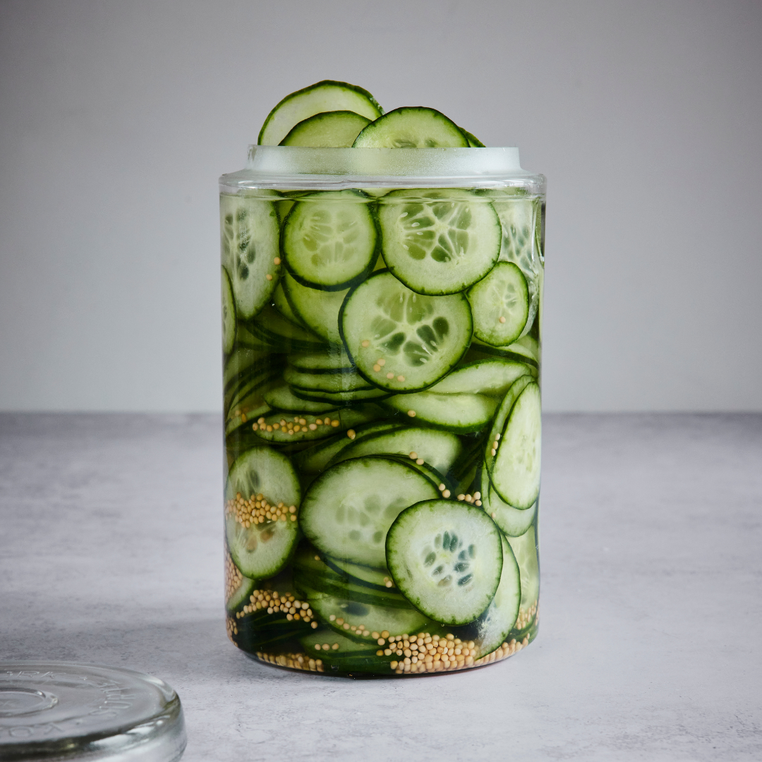 Snabbinlagd gurka i glasburk med senapsfrön och klar lag.