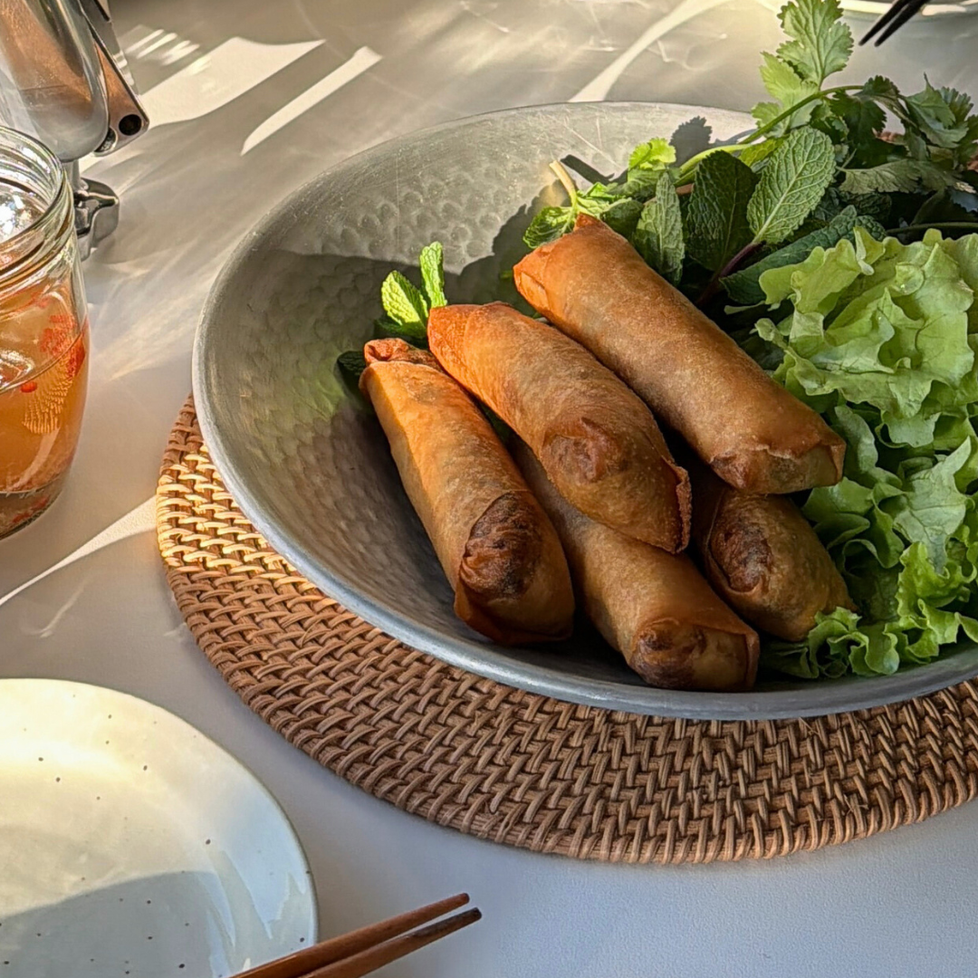 Frasiga vietnamesiska vårrullar fyllda med vårens primörer, serverade med sallad och färska örter