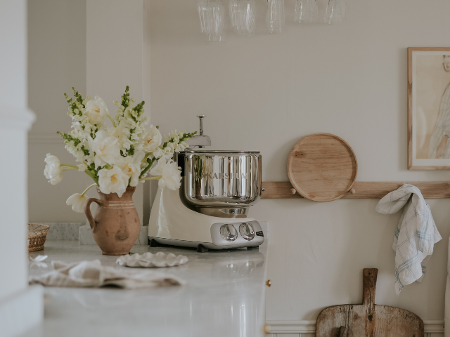The best stand mixer in the colour Creme Light with stainless steel bowl placed on a kitchen counter in a calm kitchen setting