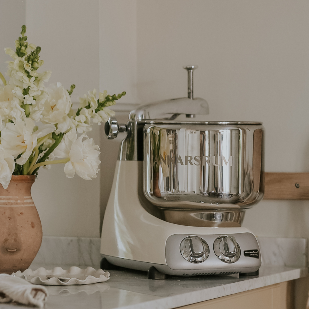 The best stand mixer with stainless steel bowl placed on kitchen counter in a calm kitchen setting